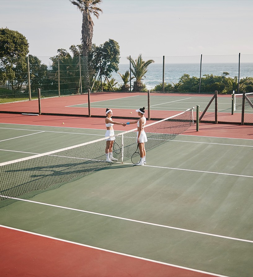 Players at an international tennis camp — ocean-side court