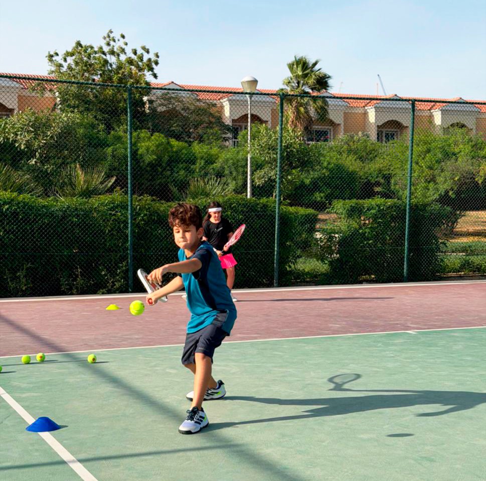 Young players practicing tennis on court