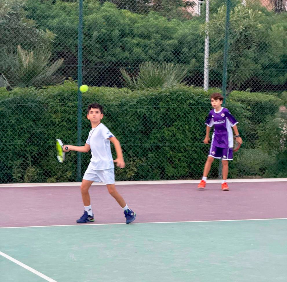 Coach instructing a young player on court