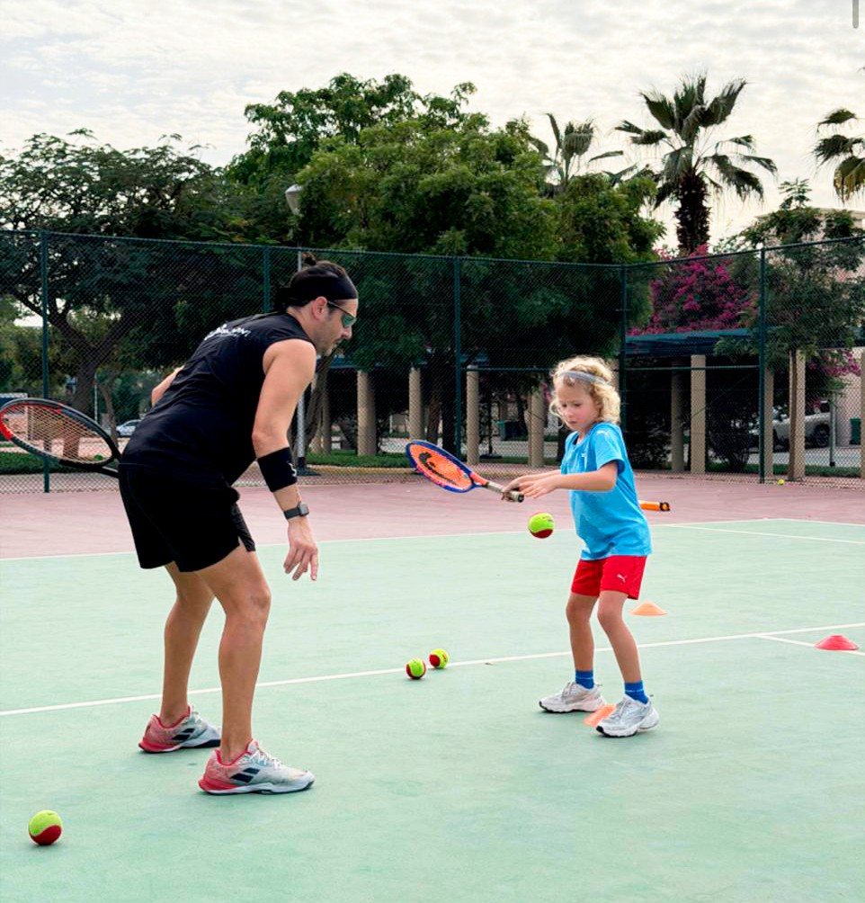 Children practicing tennis drills on outdoor court