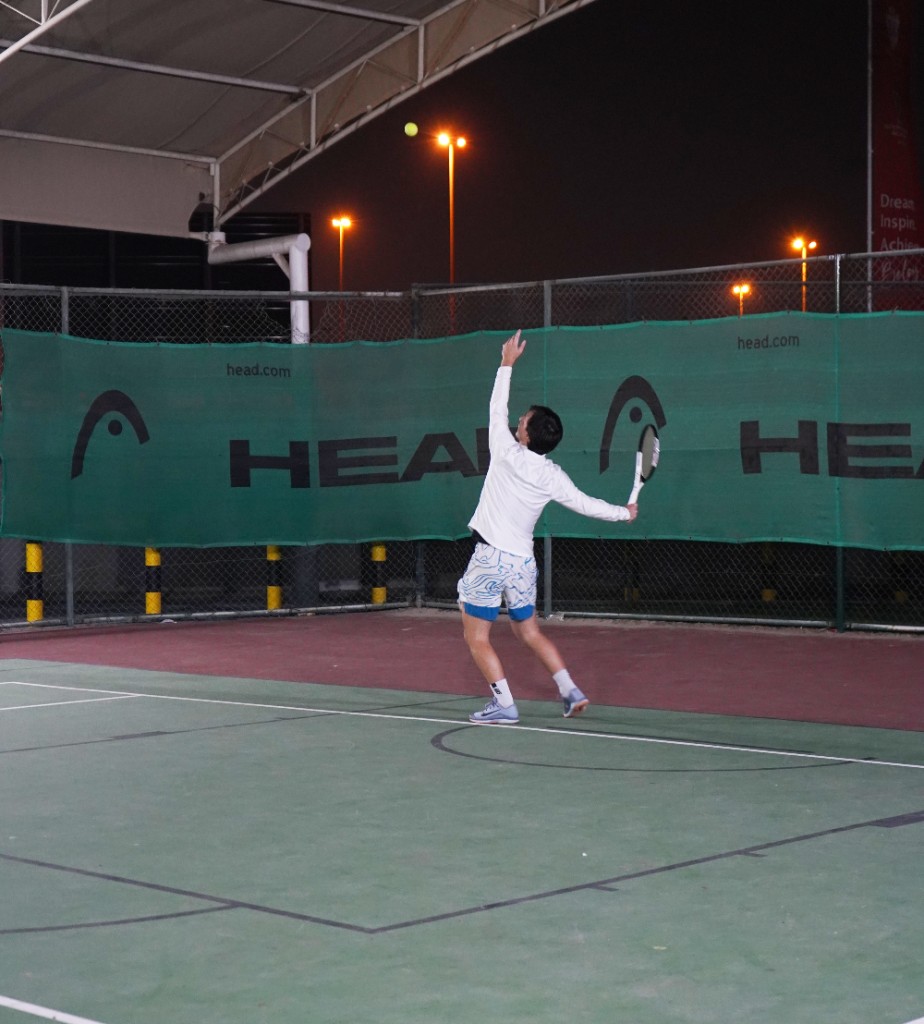 Players practicing serves on court at night